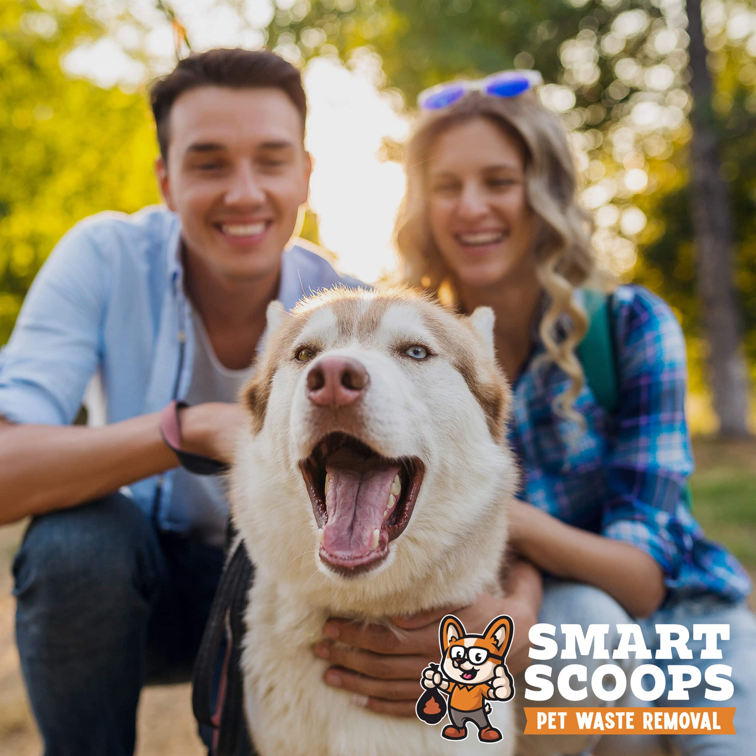 funny young stylish couple playing with dog in park